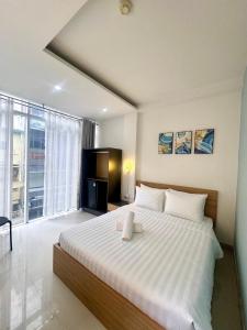 Un dormitorio con una cama grande y una ventana grande. en Atusy Boutique Hotel, en Ho Chi Minh