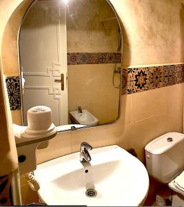 ein Badezimmer mit Waschbecken, Spiegel und Toilette in der Unterkunft A5 Bel Appartement vue mer a 300m de la plage in Agadir