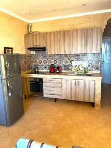 eine Küche mit einem Kühlschrank aus Edelstahl und einem Herd in der Unterkunft A5 Bel Appartement vue mer a 300m de la plage in Agadir