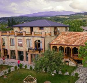 Un gran edificio de ladrillo con un porche y una terraza. en Chateau ikalto, en Ikalto