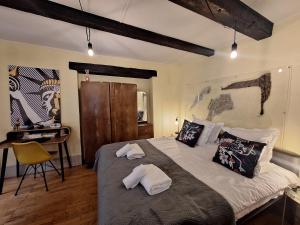 a bedroom with a large bed with two pillows at Maison Cliquot - Appartements Colmar Centre in Colmar