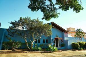 a blue house with a tree in front of it at Vivenda Del Sol in Bauru