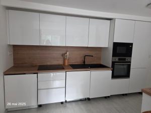 a kitchen with white cabinets and a sink and a stove at La Pineda de Provence in Aix-en-Provence