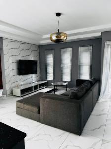 a living room with a couch and a tv at Tranquil Haven in Matsapha