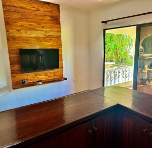a kitchen with a large counter with a tv on the wall at Jardin Marron in Baie Sainte Anne