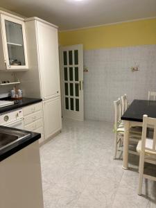 a kitchen with white cabinets and a table and chairs at Casa Lu' in San Tommaso
