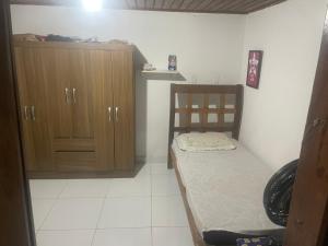 a small bedroom with a bed and wooden cabinets at Casa para alugar em Salvador in Salvador