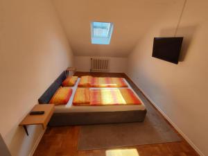 a attic bedroom with a bed and a window at No work in Ivišovo Greblje