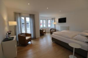 a bedroom with a bed and a living room at Landhotel Adler in Sigmarszell