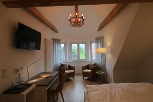 a bedroom with a desk and a room with a bed at Landhotel Adler in Sigmarszell