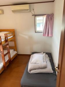 Postel nebo postele na pokoji v ubytování GuestHouse AIZU