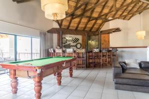 a living room with a pool table and chairs at Zebula Golf Estate & Spa Executive Holiday Homes in Mabula