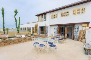 a patio with a table and chairs in front of a building at Dar Tya Rabat Salé Marina in Sale