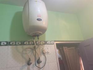 a hair dryer on the wall of a bathroom at The hidden heaven homestay kalpa in Chini +10 photos