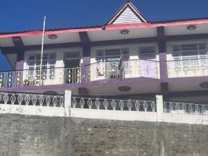 a house with a balcony and a fence at The hidden heaven homestay kalpa in Chini