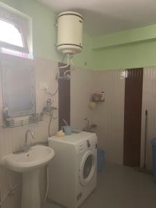 a bathroom with a washing machine and a sink at The hidden heaven homestay kalpa in Chini
