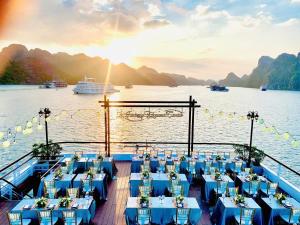 um barco com mesas e cadeiras azuis na água em Le Journey Elegance Cruise em Ha Long