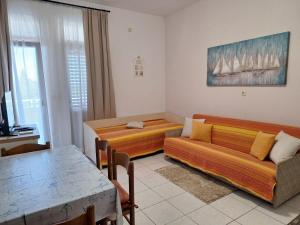 a living room with two beds and a couch at Apartments Gržanov in Sutomišćica