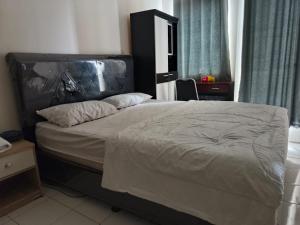 ein Schlafzimmer mit einem großen Bett mit schwarzem Kopfteil in der Unterkunft Dahoma lantai 6 in Tjikuda Tiga
