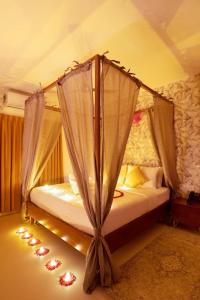 a bedroom with a canopy bed with lights on the floor at Bangalore Hideaway 1BHK Spanish villa Casa Rio in Denkanikota