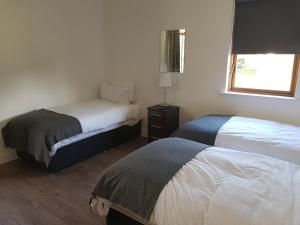 Postel nebo postele na pokoji v ubytování Woodlands Lodges Mulranny