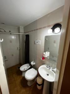 a bathroom with a toilet and a sink and a mirror at HColon in Colón +14 photos
