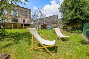 two chairs sitting in the grass in a yard at Maison 5 chambres #10 personnes #Jardin in Cognac