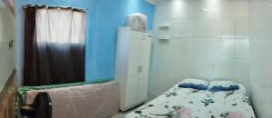 a small room with a bed and a shower at Kitnet chegada de Porto B in Porto Seguro