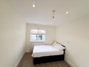 a small white bedroom with a bed in it at Luxury, comfort and Elegant Home in Hillingdon