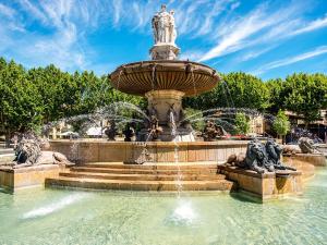 a fountain in a park with two statues at La Pineda de Provence in Aix-en-Provence