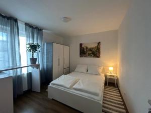 フランクフルト・アム・マインにあるSunnyApartmentsの白いベッドと窓のある小さな寝室