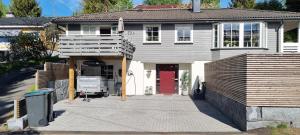 a white house with a red door and a porch at Detached house close to nature and city life in Oslo