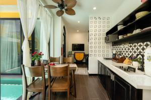 a kitchen with a table and chairs and a dining room at Hoi An 2BR private Pool Villa - Walk to Old Town in Hoi An