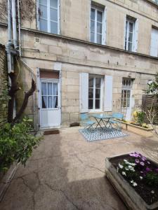 a patio with a table and chairs in front of a building at Charmant studio avec cour privée in Rochefort