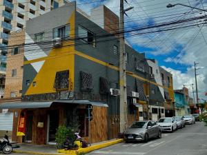 a yellow and gray building on a city street at Residence Fonteles in Sobral