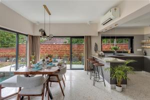 a kitchen and dining room with a table and chairs at Villa Reverie By AT Villas in Vagator