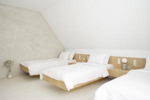 zwei Betten in einem Zimmer mit weißen Wänden in der Unterkunft Hotel Hello Plovdiv - Free Parking and Pet Friendly in Plowdiw