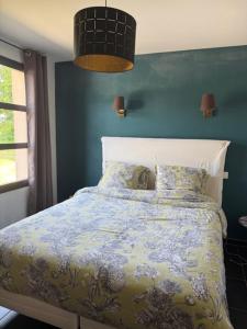 a bedroom with a bed with a blue wall at Le clos du Broca in Clermont-Pouyguilles +16 photos