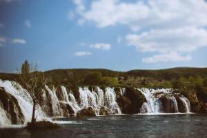 a waterfall in the middle of a body of water at River huts Zrmanja in Obrovac