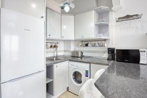 a white kitchen with a washer and dryer in it at Lenas Apartments Pedro Lorca in Torrevieja