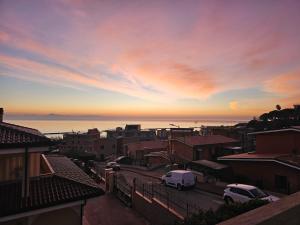 a city with cars parked in a street at sunset at Alba sul Mare Apartment in Campofilone