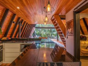 eine Küche mit langem Tisch und Holzdecken in der Unterkunft Cabana Memórias in Gramado