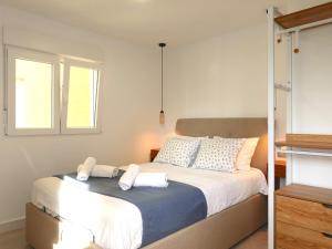 ein Schlafzimmer mit einem Bett mit weißen Laken und einem Fenster in der Unterkunft Apartamento 3 habitaciones y 3 baños Playa de Gandía in Playa de Gandia