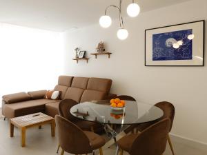 ein Wohnzimmer mit einem Glastisch und einer Couch in der Unterkunft Apartamento 3 habitaciones y 3 baños Playa de Gandía in Playa de Gandia