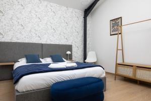 Un dormitorio con una cama y una silla azul. en Le Domaine de la Haye - Gîtes, en Saint-Christophe-du-Bois 50 fotos más