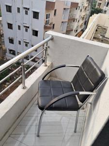 einen Stuhl auf dem Vorsprung eines Balkons in der Unterkunft Arsh Mahal in Pune + 7 Fotos