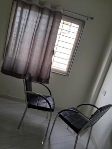 a chair sitting in a room with a window at Arsh Mahal in Pune
