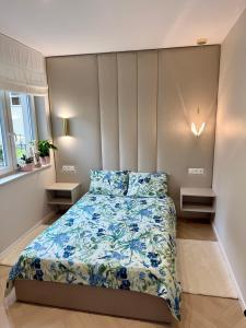 a bedroom with a bed with a blue comforter at Apartament Kaszmirowy in Bielsko-Biała