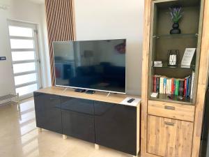 a large flat screen tv sitting on top of a cabinet at Villetta Mia in Njivice