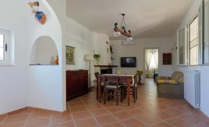 ein Wohnzimmer mit Tisch und ein Esszimmer in der Unterkunft Villa dei Tigli - trulli e relax in Castellana Grotte